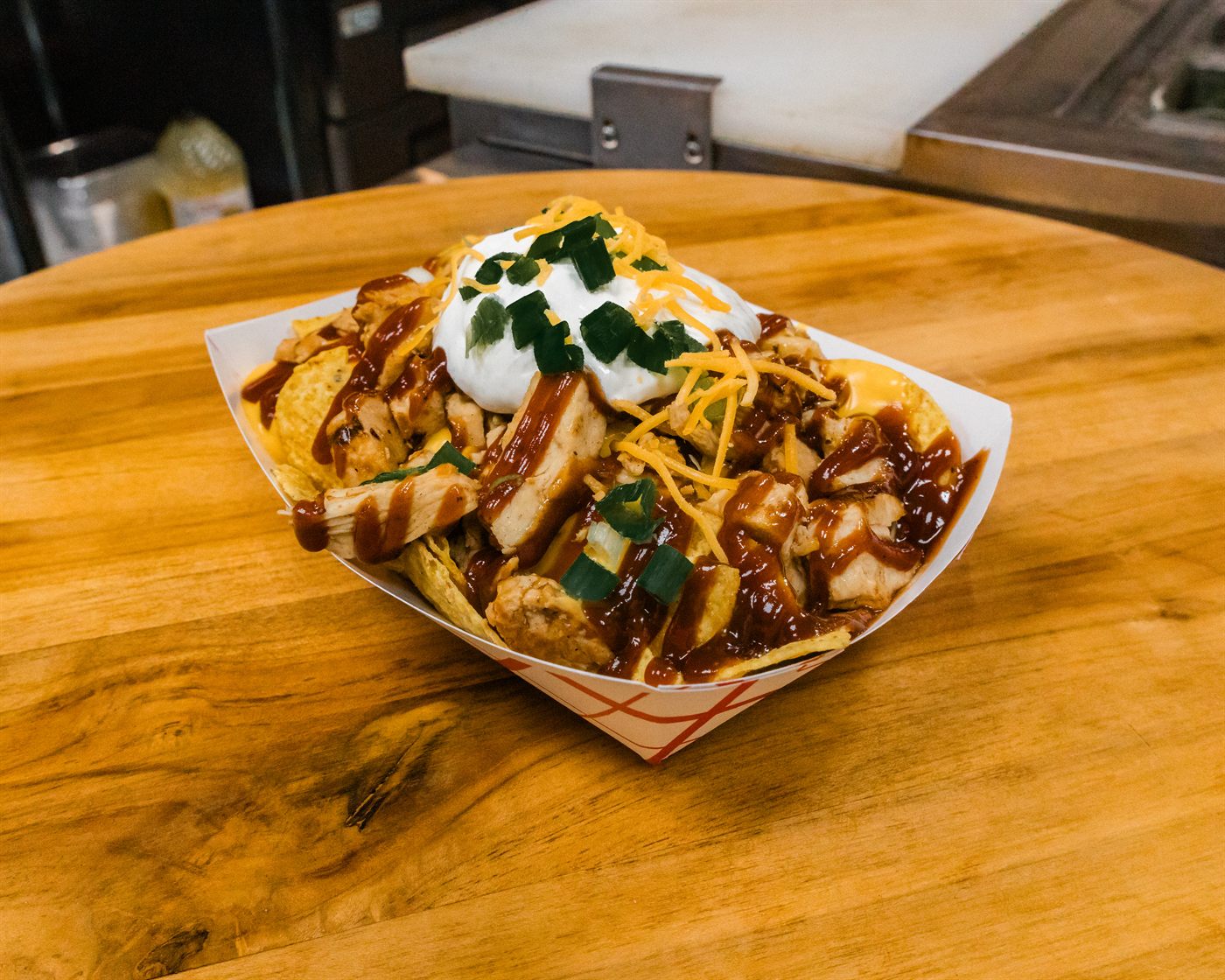 Loaded BBQ potato bowl with chicken, cheese, sour cream, and green onions